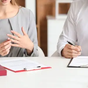 A woman and a lawyer sitting at a table with papers, discussing divorce proceedings - DC Nguyen Law